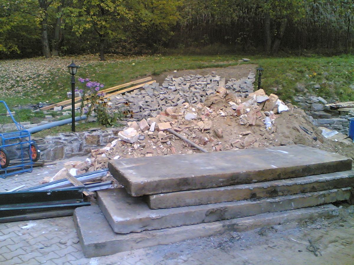 A pile of demolition debris with broken concrete slabs in the foreground